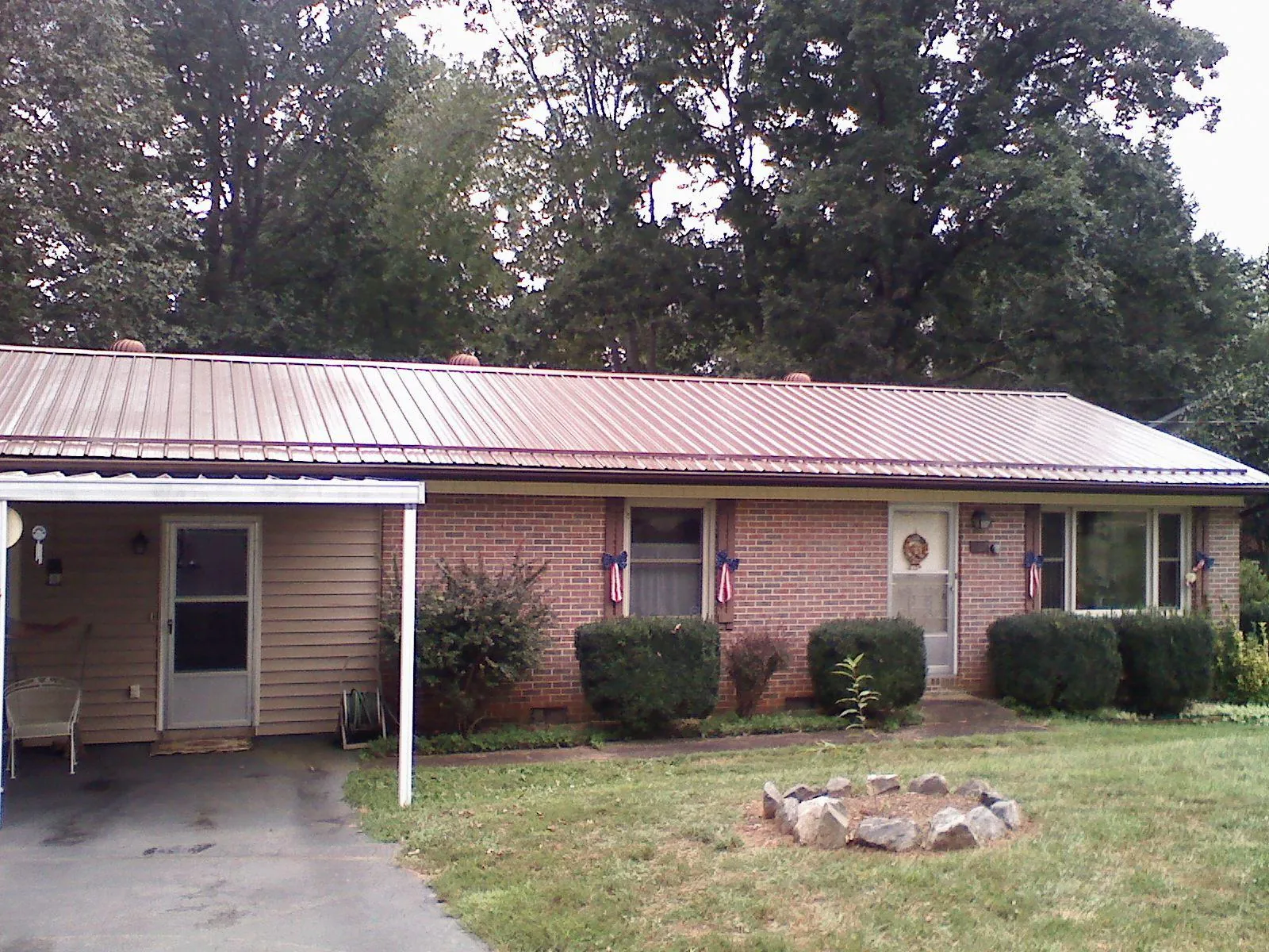 Bronze metal roof and carport on a brick ranch home — Roof Repair work by our crew in Miami Gardens
